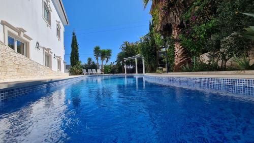 a blue swimming pool next to a building at Villas de Nazare in Maceira