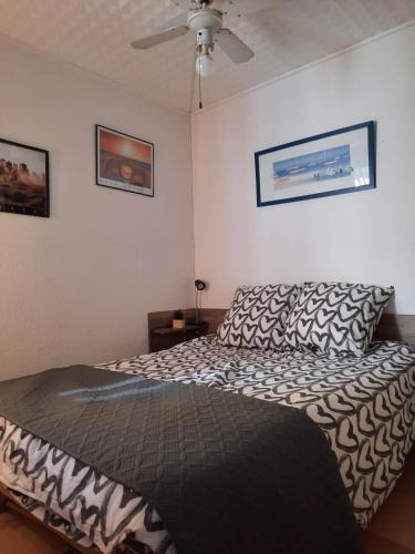 une chambre avec un lit et un ventilateur de plafond dans l'établissement Appartement en Résidence avec piscine proche mer, au Barcarès