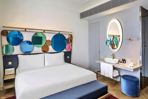 a bedroom with a bed with a mirror and a sink at W Prague in Prague
