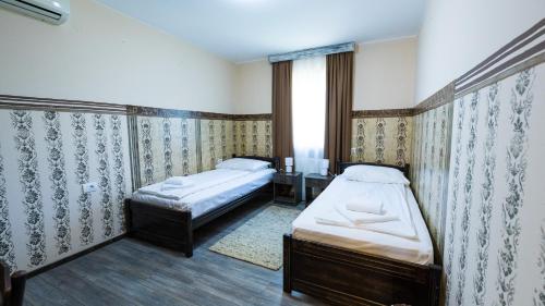 a bedroom with two beds and a window at Imanje Borkonjić in Ruma