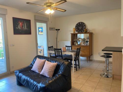 un salon avec un canapé en cuir et une table dans l'établissement Appartement T3 63 m2 rez-de-chaussée, residence Schweitzer 2 chambres garage et jardin, à Aix-les-Bains