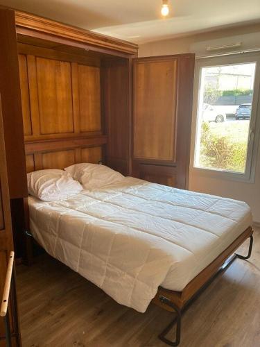 un grand lit dans une chambre avec une fenêtre dans l'établissement Appartement T3 63 m2 rez-de-chaussée, residence Schweitzer 2 chambres garage et jardin, à Aix-les-Bains