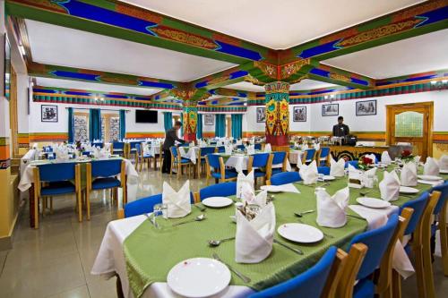 a banquet hall with tables and chairs and people in the background at Hotel Royal Ladakh, Leh in Leh