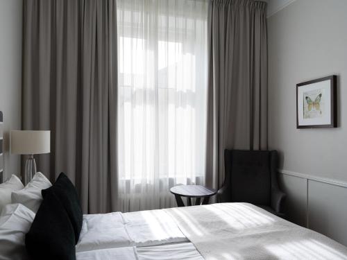 a hotel room with a bed and a chair and a window at Elite Stora Hotellet Örebro in Örebro