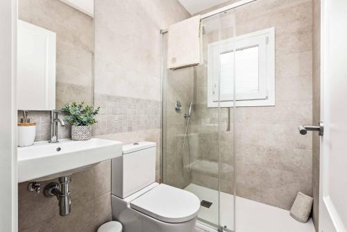 a bathroom with a toilet and a sink and a shower at Casa Maria in Cala Galdana