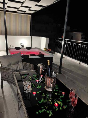 a room with a table with flowers on a balcony at JACUZZI penthouse - King's view in Artemida