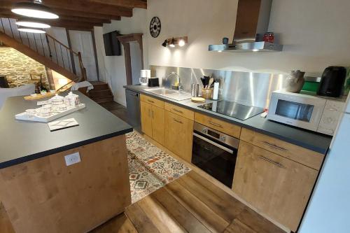 a kitchen with a sink and a microwave at Gîte 8 pers avec jacuzzi et jardin Aurillac in Arpajon-sur-Cère