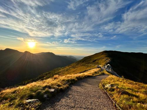 a path on top of a mountain with the sunset at Gîte 8 pers avec jacuzzi et jardin Aurillac in Arpajon-sur-Cère