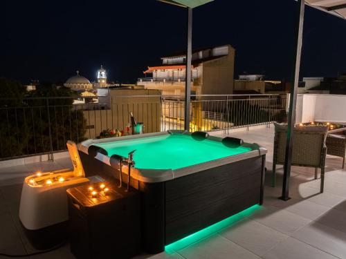 a pool with lights on a balcony at night at JACUZZI penthouse - King's view in Artemida