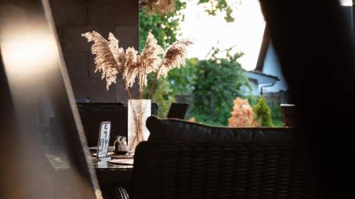 a table with a chair and a vase with a plant at SergJuli Villa in Plavecký Štvrtok