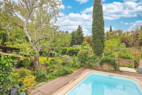 a swimming pool in the middle of a garden at O Grand Air in Saint-Saturnin-lès-Avignon