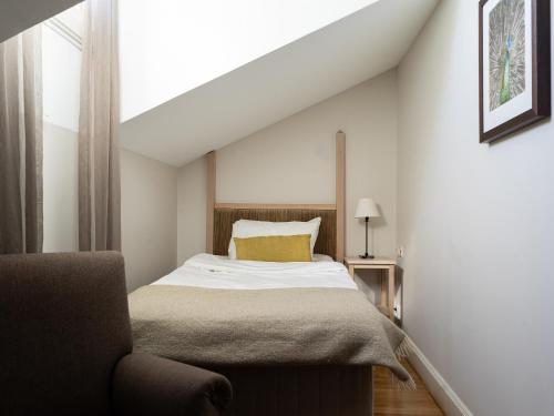 a bedroom with a bed and a chair at Elite Stora Hotellet Örebro in Örebro
