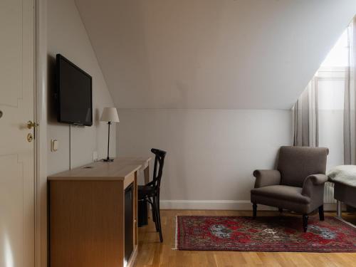 a room with a desk and a chair and a television at Elite Stora Hotellet Örebro in Örebro
