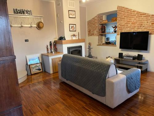 a living room with a couch and a tv at La casa di Noah in Bene Vagienna