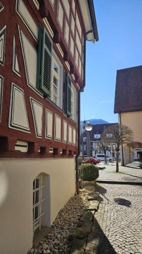 a building with green shuttered windows and a cobblestone street at Altes Pfarrhaus Hotel und Restaurant in Bad Überkingen