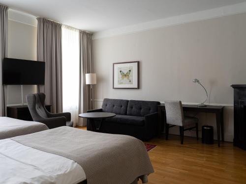 a hotel room with a bed and a couch at Elite Stora Hotellet Örebro in Örebro
