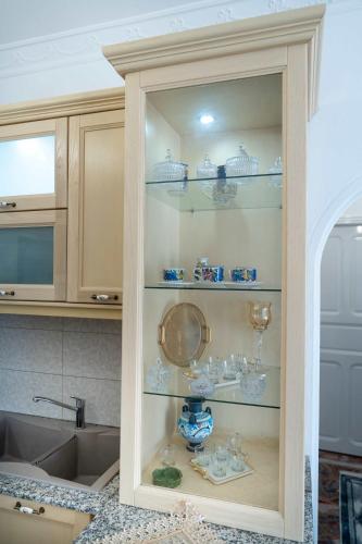 a cabinet filled with glass items in a kitchen at Dream House in Kalymnos