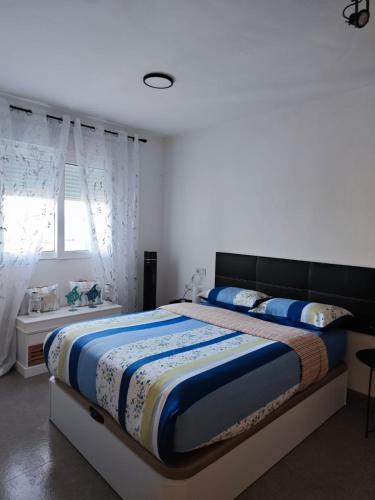 a bedroom with a large bed with blue and white sheets at La Manga beach has everything in San Javier