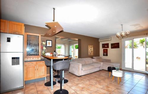 une cuisine et un salon avec un canapé et une table dans l'établissement Awesome Home In Saleilles, à Saleilles