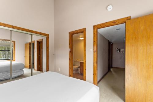 a bedroom with a white bed and a bathroom at Rockridge 59 by Summit County Mountain Retreats in Breckenridge