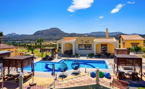 a swimming pool with chairs and a house at Villa Rose in Kolimbia