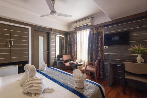 a hotel room with a bed with towels at Hotel Pravasa Stay in Vadodara
