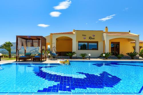 a large swimming pool in front of a house at Villa Rose in Kolimbia
