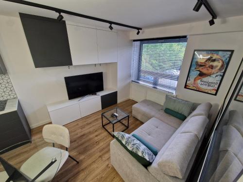 a living room with a couch and a flat screen tv at Apartament Soft Modern in Serock