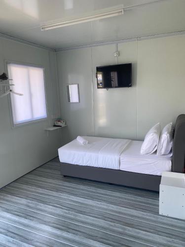 a bedroom with a bed and a tv on the wall at 1108 Pedas Village Resort in Pedas