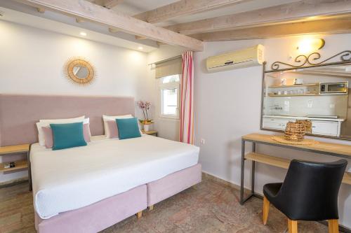 a bedroom with a large bed and a desk at KORINA APART HOTEL KAVOS in Kavos