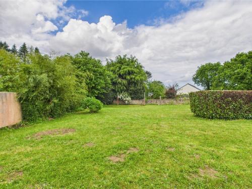 a yard with green grass and bushes and trees at -SUZANNE- Maison de charme au coeur de Nevez in Névez