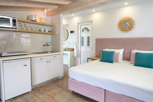 a bedroom with a large bed and a kitchen at KORINA APART HOTEL KAVOS in Kavos