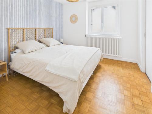 a bedroom with a large bed with a wooden floor at -SUZANNE- Maison de charme au coeur de Nevez in Névez