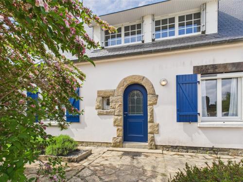 a blue door on a white house with flowers at -SUZANNE- Maison de charme au coeur de Nevez in Névez