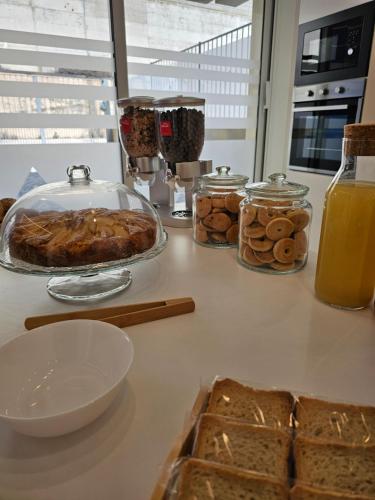 a table with bread and jars of orange juice and food at Aura B&B in Pachino