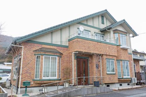 a brick house with a balcony on top of it at 夢 HAKONE Villa 030H in Hakone