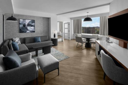 a living room with a couch and a tv at AC Hotel Arlington National Landing in Arlington
