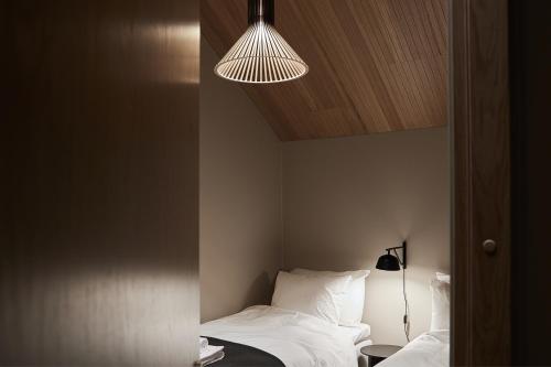 a bedroom with two beds and a light fixture at Stay North - The House of Northern Lights in Äkäslompolo