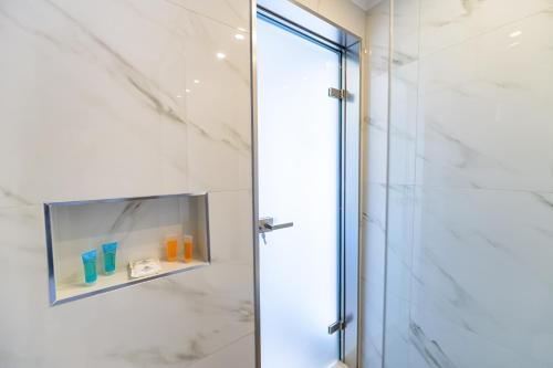 a shower stall with a glass door in a bathroom at KORINA APART HOTEL KAVOS in Kavos