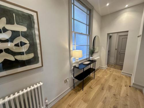 a living room with a desk and a painting on the wall at Halliford By Pureserviced in Plymouth