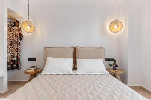 a bedroom with a bed with two lamps and two tables at Golden Bay in Agios Prokopios