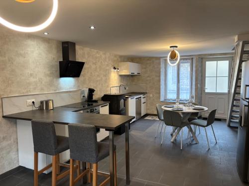 une cuisine et une salle à manger avec une table et des chaises dans l'établissement Le repos du voyageur, à Rolampont