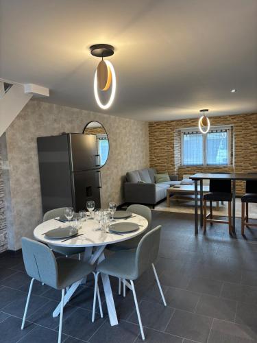 un salon avec une table, des chaises et un canapé dans l'établissement Le repos du voyageur, à Rolampont