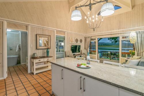 a large kitchen with a island and a view of the ocean at Knysna River Club Getaways - Luxury waterfront chalets in Knysna