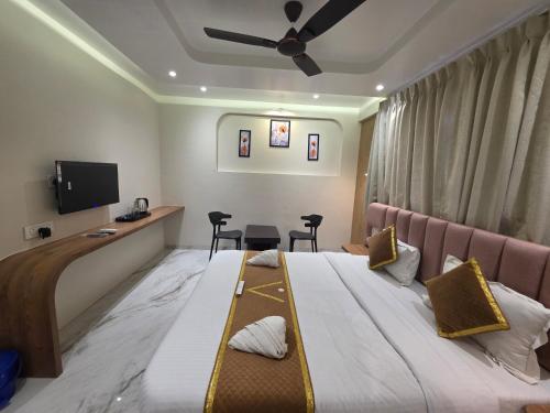 a hotel room with two beds and a flat screen tv at Hotel Vyankatesh & Pure Veg Restaurant in Mahabaleshwar