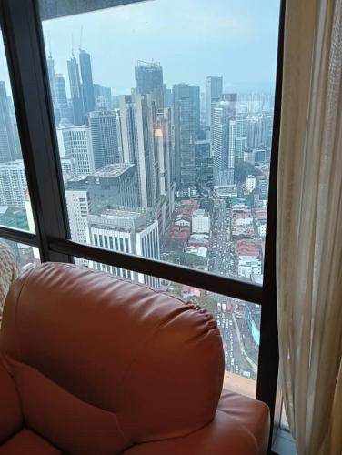 a couch in front of a window with a view of a city at My Service Suites Times Square KL in Kuala Lumpur