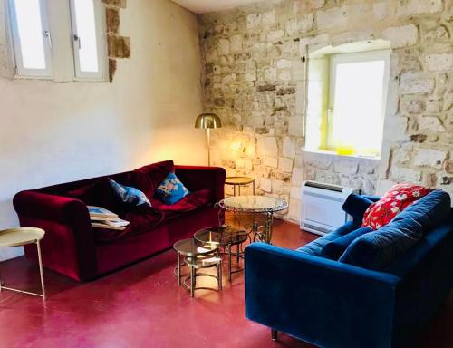 - un salon avec deux canapés et un mur en pierre dans l'établissement Belle maison historique, à Arles