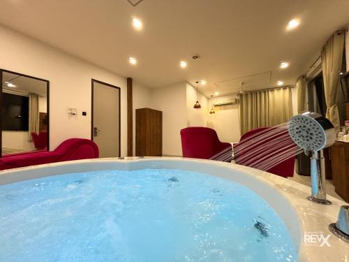 a hot tub in a room with red chairs at The Neeraj River Forest Resort Ayurvedic Wellness Center in Rishīkesh