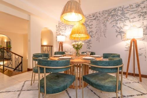 a dining room with a table and green chairs at Riverside Park Complex in Nairobi
