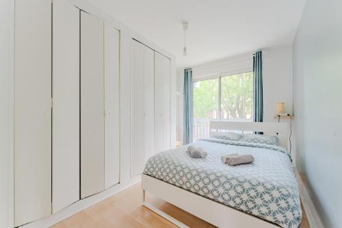 une chambre blanche avec un lit et une fenêtre dans l'établissement Magnifique 3 pièces avec Parking privé et balcon, à Lille